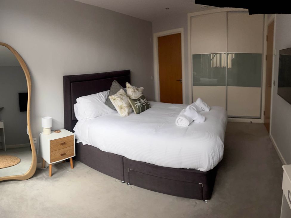 A bedroom with a bed and side table at Fistral Apres Surf in Newquay
