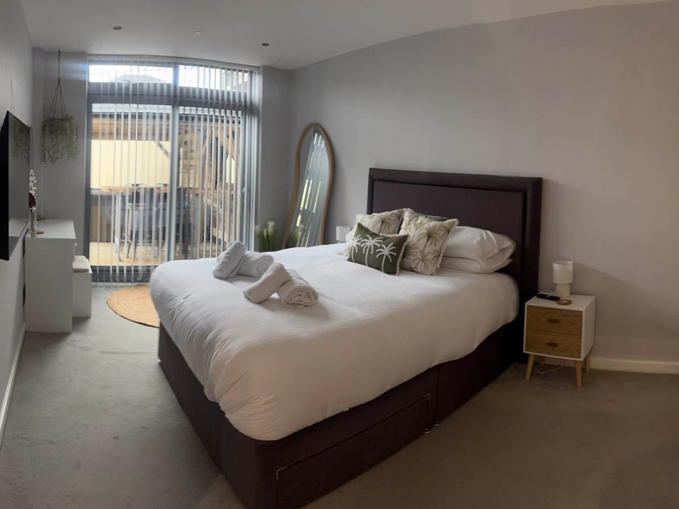 A bedroom with a bed and mirror at Fistral Apres Surf in Newquay