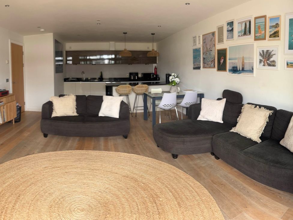 A living room with sofas and a dining area at Fistral Apres Surf in Newquay
