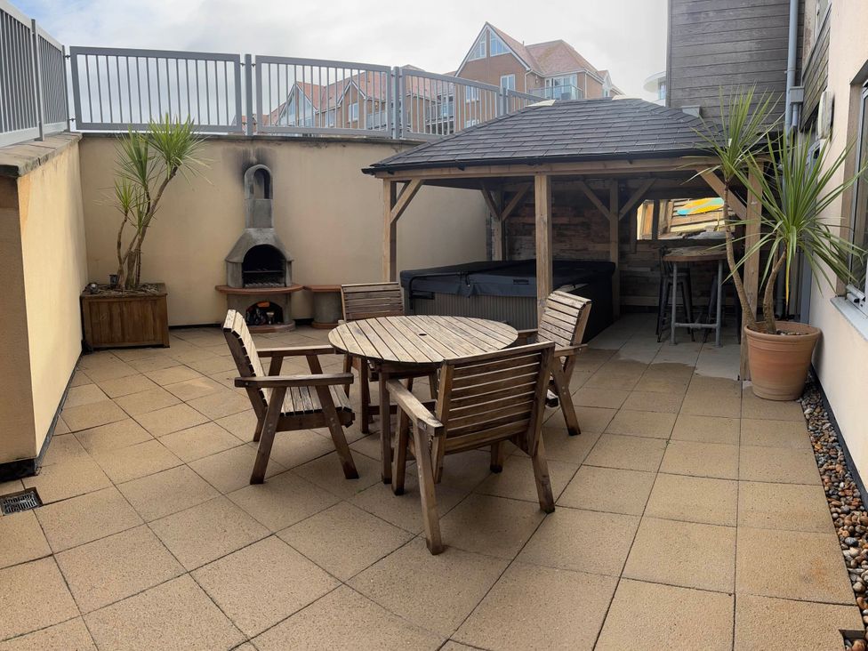 An outdoor area with a wooden table and chairs plus a hut at Fistral Apres Surf in Newquay