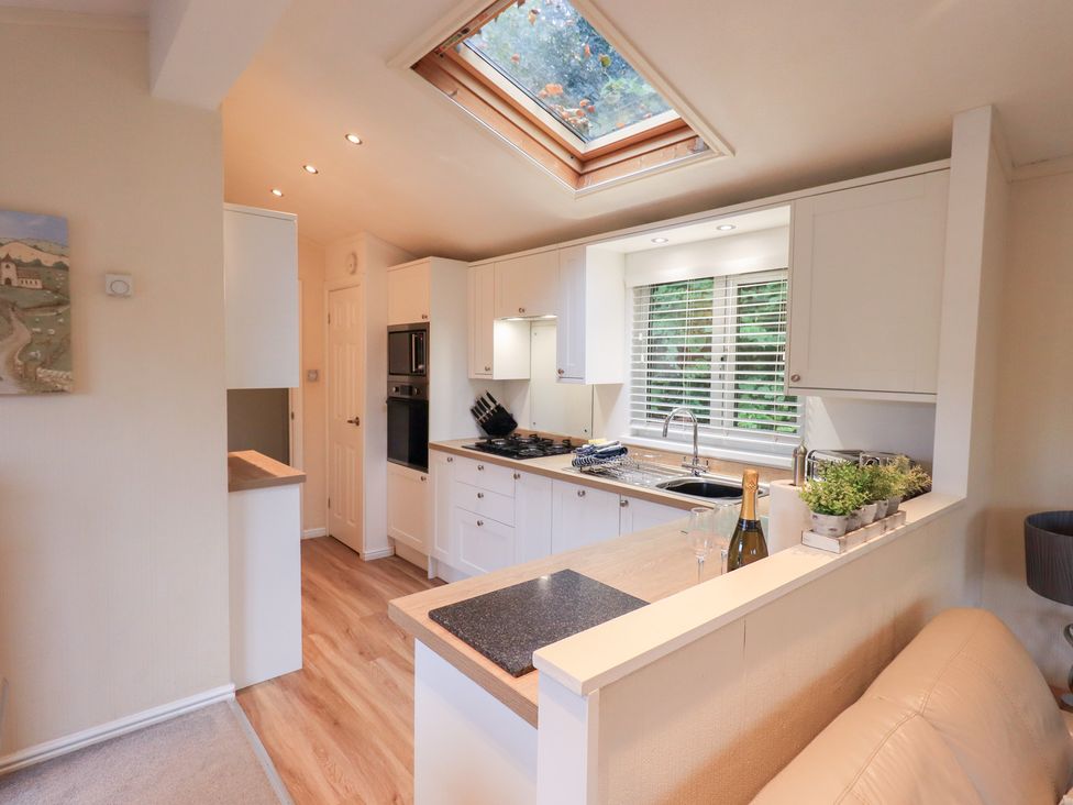 A kitchen with a sink and stove at Acorn Bank Lodge, L 55, Fallbarrow Park near Bowness-On-Windermere