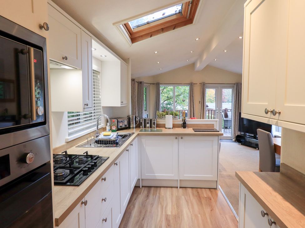 A kitchen with a sink and gas stove at Acorn Bank Lodge in L 55, Fallbarrow Park near Bowness-On-Windermere