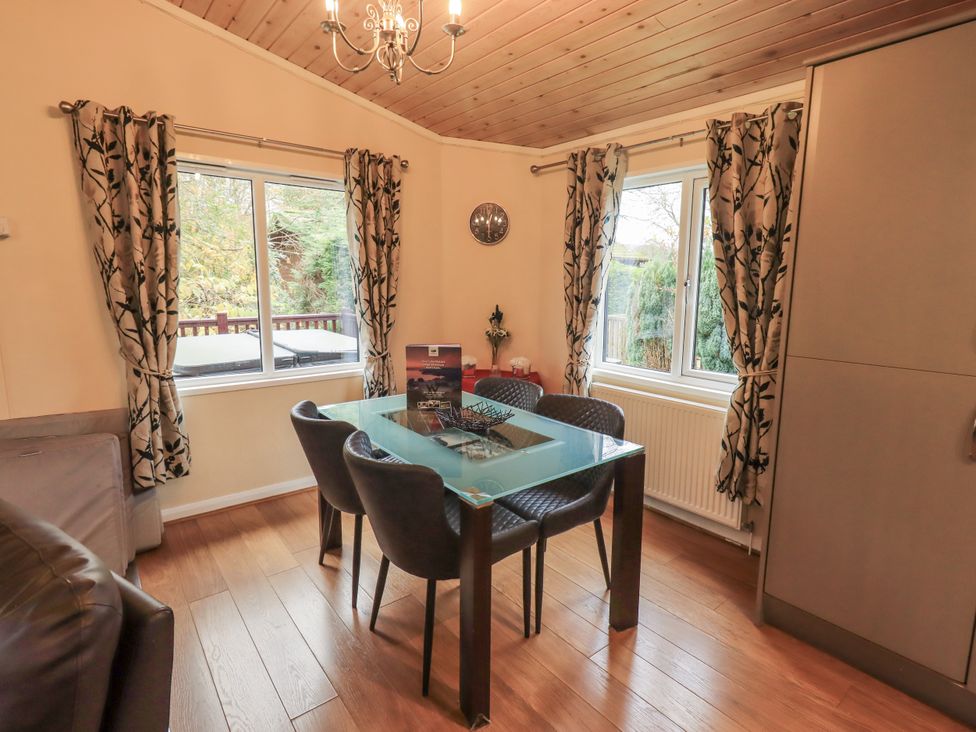 A dining room with a table and chairs at Damson Lodge, Thirlmere 8, White Cross Bay, Windermere
