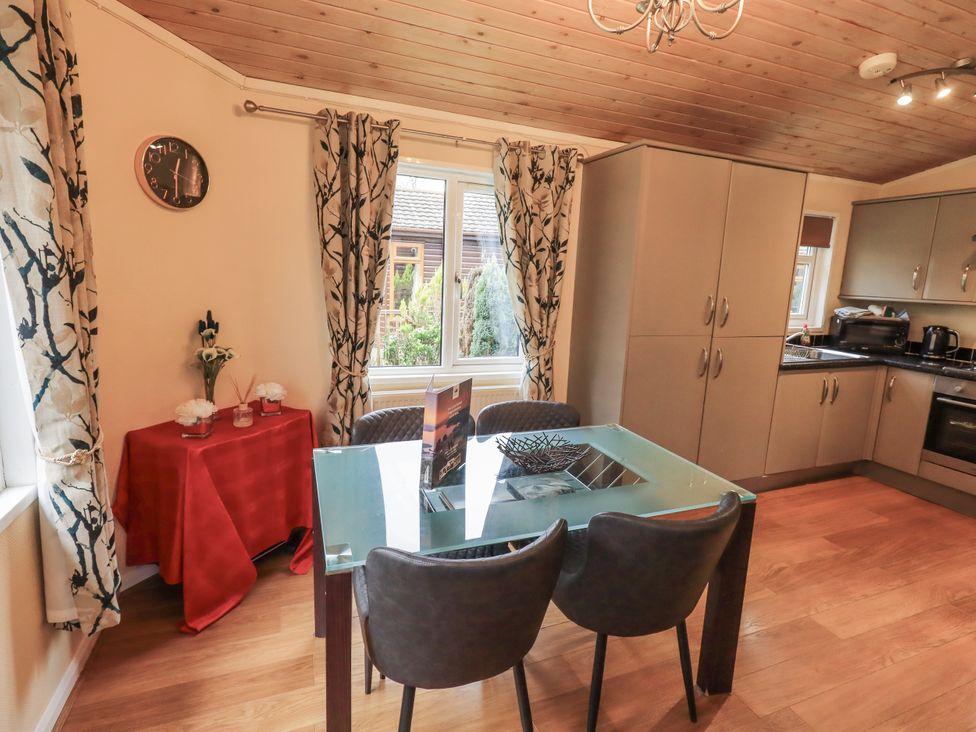 A dining room with a table and chairs at Damson Lodge, Thirlmere 8, White Cross Bay, Windermere