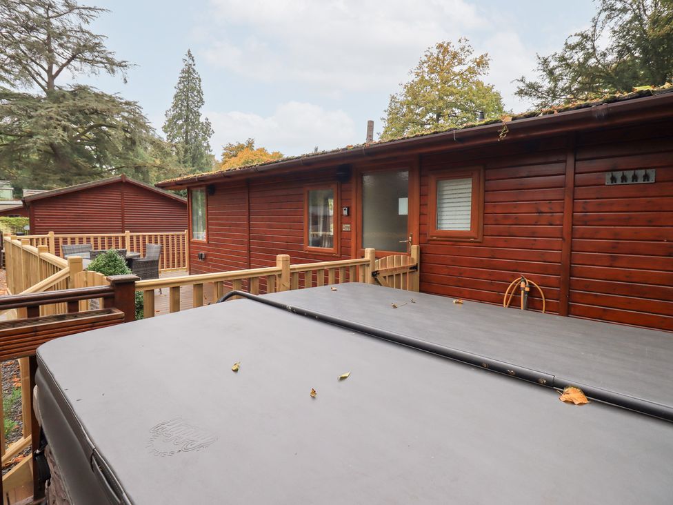An outdoor area with a hot tub and wooden decking at Buttermere Lodge in Glade 5, Fallbarrow Park near Bowness on Windermere