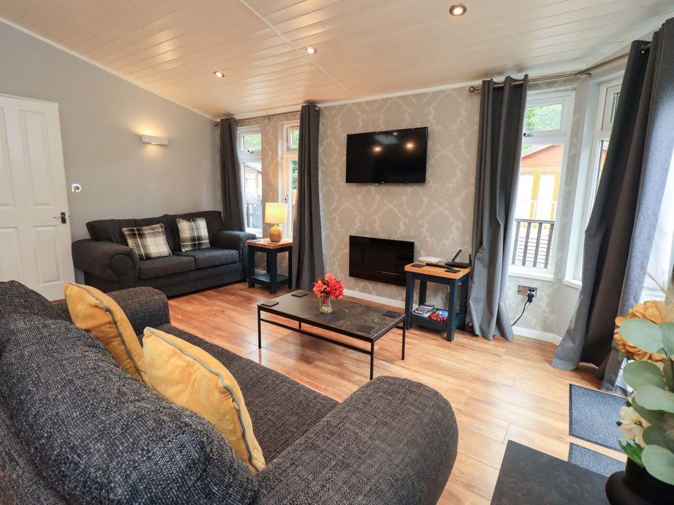 A living room with a television and sofas at Rydal Lodge Grasmere 24, White Cross Bay near Windermere