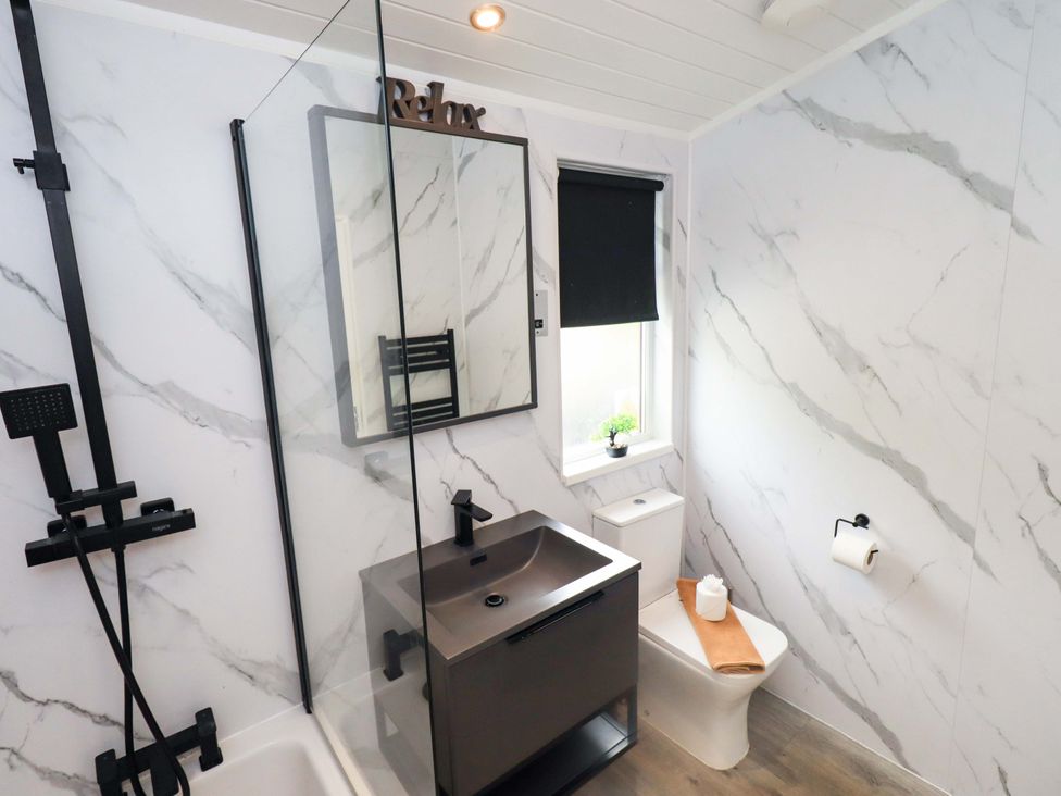 A bathroom with a shower, sink and toilet at Rydal Lodge Grasmere 24, White Cross Bay near Windermere