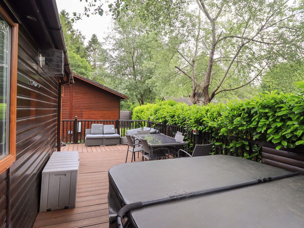 An outdoor deck area with seating and a hot tub at Rydal Lodge Grasmere 24, White Cross Bay near Windermere