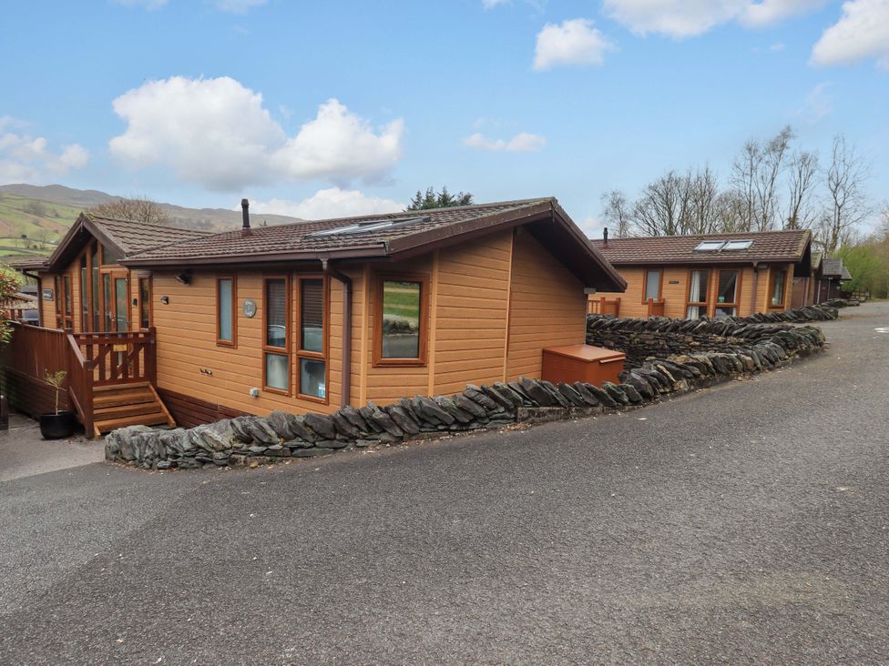 Two wooden cabins surrounded by stone walls at Elder Lodge Kirkstone 5 Limefitt Park near Windermere