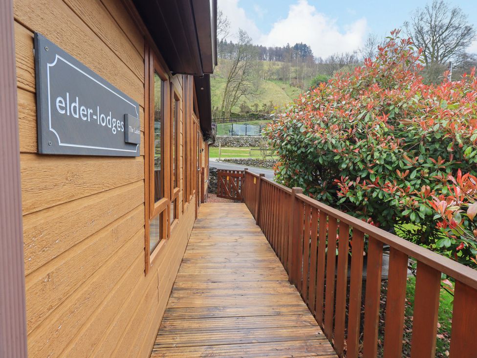 A wooden pathway leading to a lodge with a sign at Elder Lodge Kirkstone 5 Limefitt Park near Windermere
