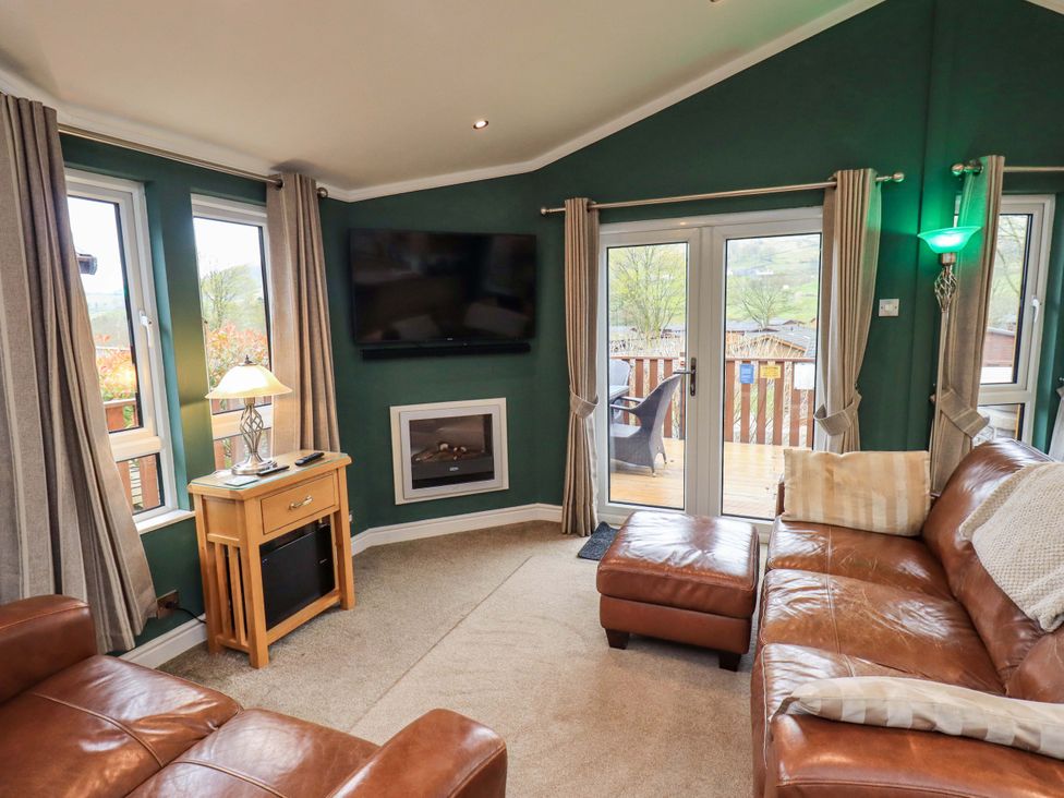 A living room with a sofa and television at Elder Lodge, Kirkstone 5, Limefitt Park near Windermere