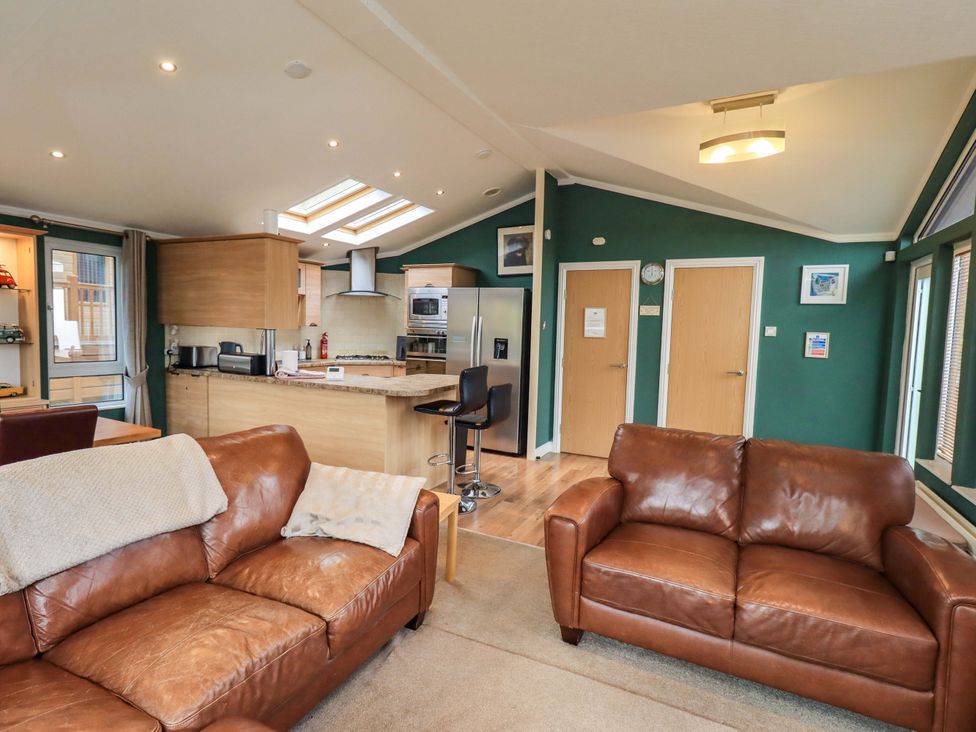 A living room with a kitchen and seating area at Elder Lodge Kirkstone 5 Limefitt Park near Windermere