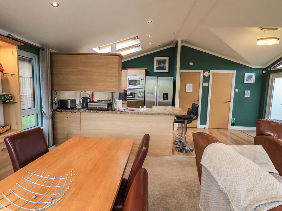 A kitchen with a dining table and chairs at Elder Lodge Kirkstone 5 Limefitt Park near Windermere