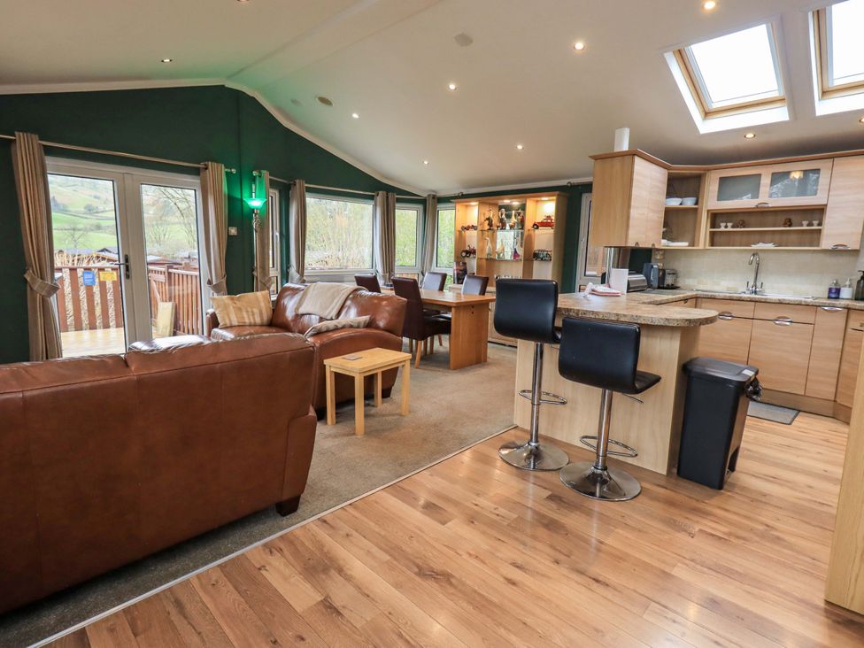 A living room with seating area and kitchen at Elder Lodge, Kirkstone 5, Limefitt Park near Windermere