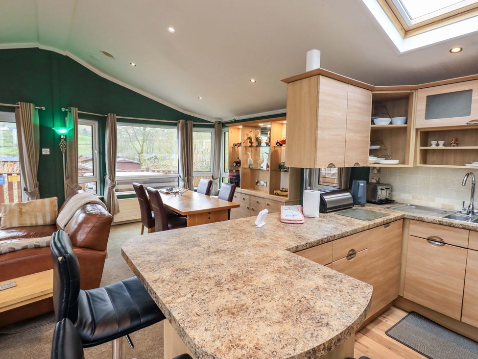 A kitchen with dining table and sofas at Elder Lodge Kirkstone 5 Limefitt Park near Windermere