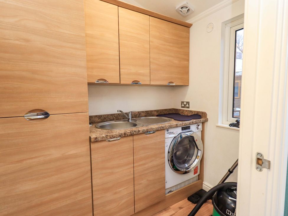 A laundry room with a washing machine and sink at Elder Lodge Kirkstone 5 Limefitt Park near Windermere