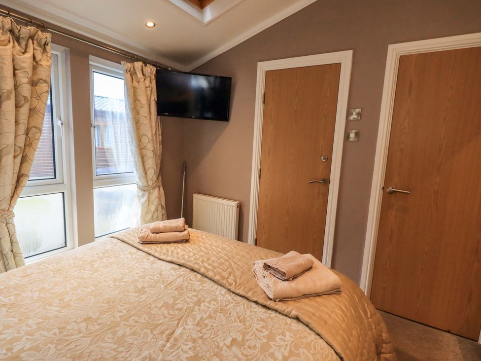 A bedroom with a bed and television at Elder Lodge Kirkstone 5 Limefitt Park near Windermere