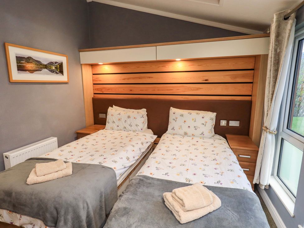 A bedroom with two single beds and a window at Elder Lodge, Kirkstone 5, Limefitt Park near Windermere