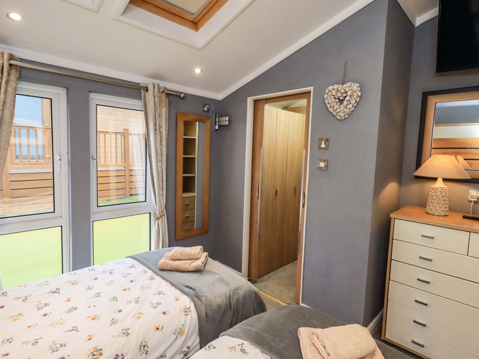 A bedroom with two beds and a wardrobe at Elder Lodge, Kirkstone 5, Limefitt Park near Windermere