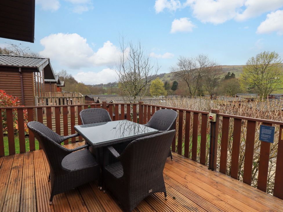 A deck with a table and chairs overlooking a natural landscape at Elder Lodge Kirkstone 5, Limefitt Park near Windermere