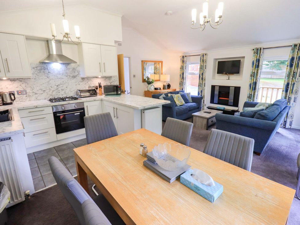 A living room and kitchen area with furniture at Forest Pines Lodge Beech Hill 10 Fallbarrow Park near Bowness on Windermere