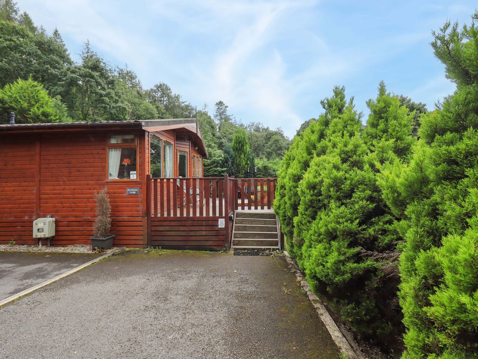 An outdoor view of a lodge with a wooden deck at Birthwaite Lodge, Fellside 6, Limefitt Park near Windermere