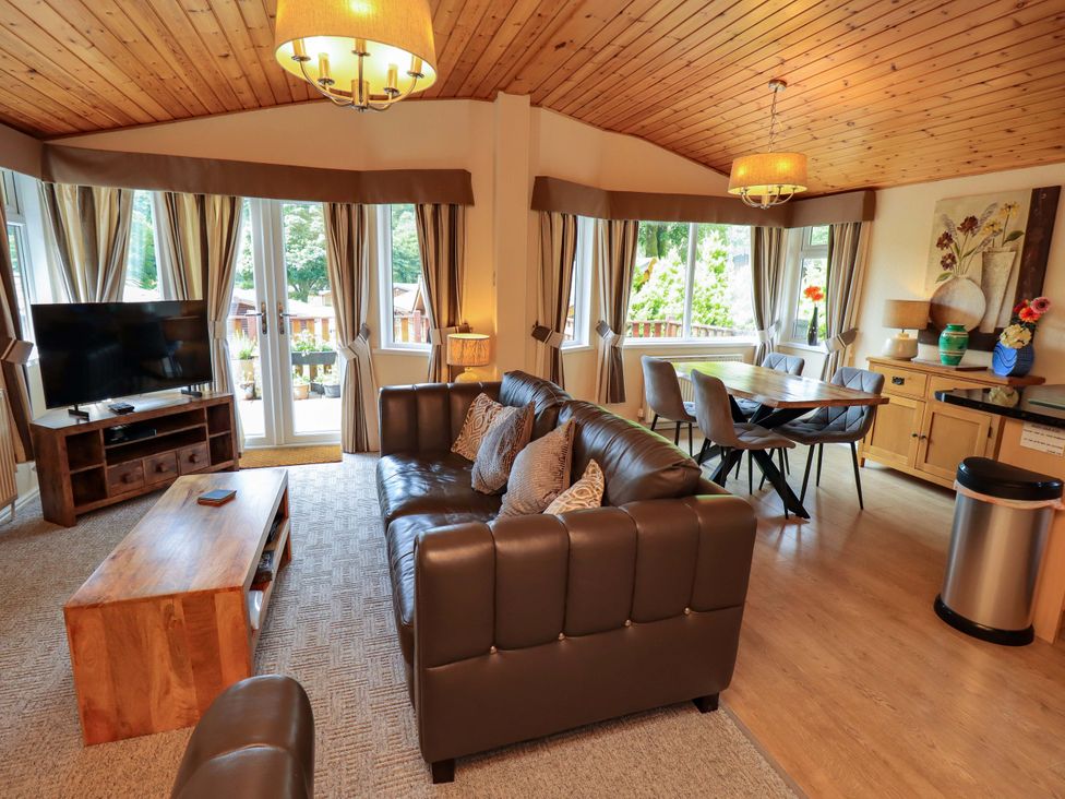 A living room with a sofa and television at Birthwaite Lodge Fellside 6 Limefitt Park near Windermere