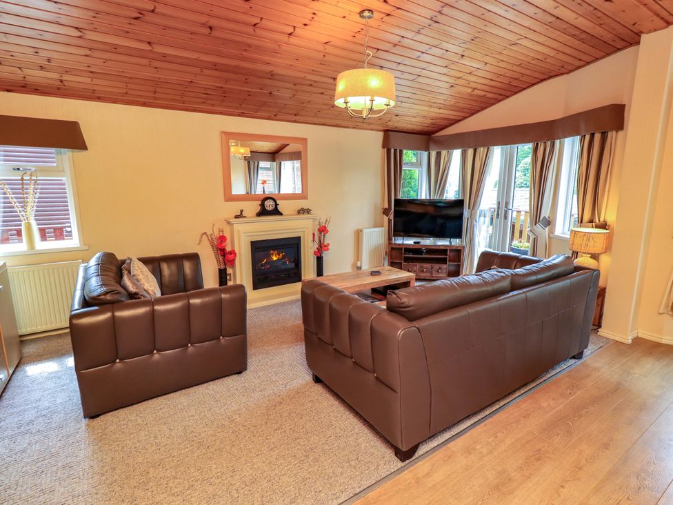 A living room with seating and a fireplace at Birthwaite Lodge, Fellside 6, Limefitt Park near Windermere