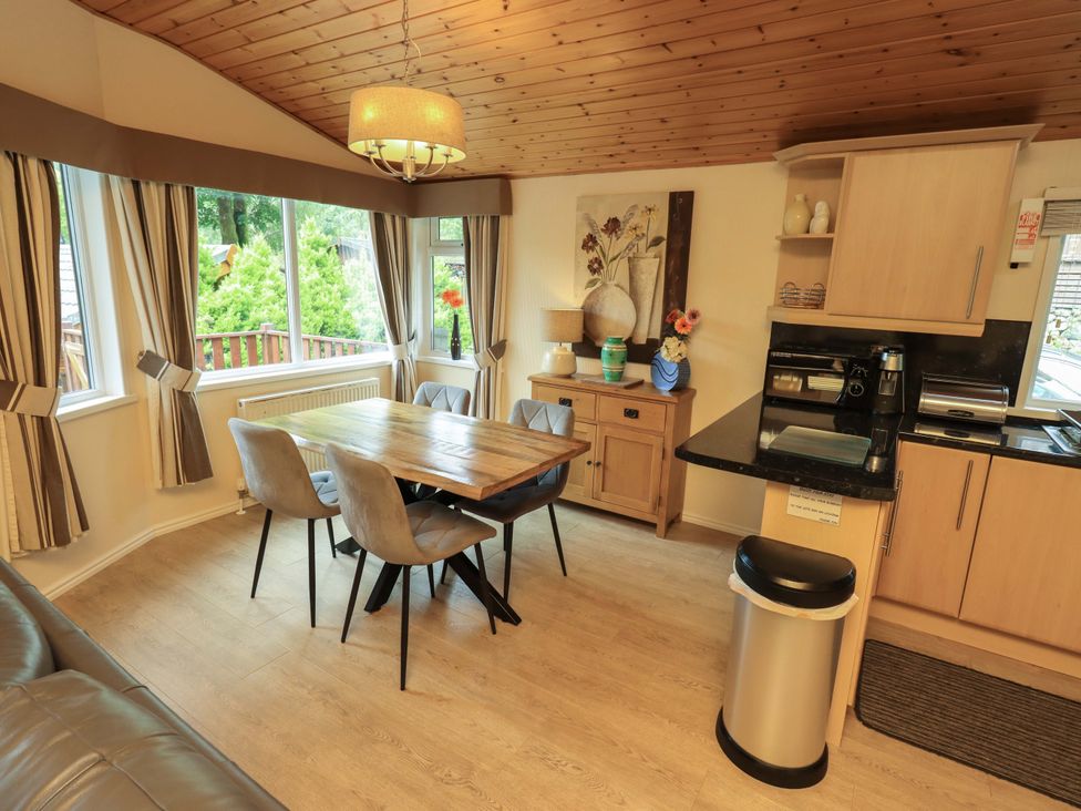 A dining room with a wooden table and chairs at Birthwaite Lodge, Fellside 6, Limefitt Park near Windermere