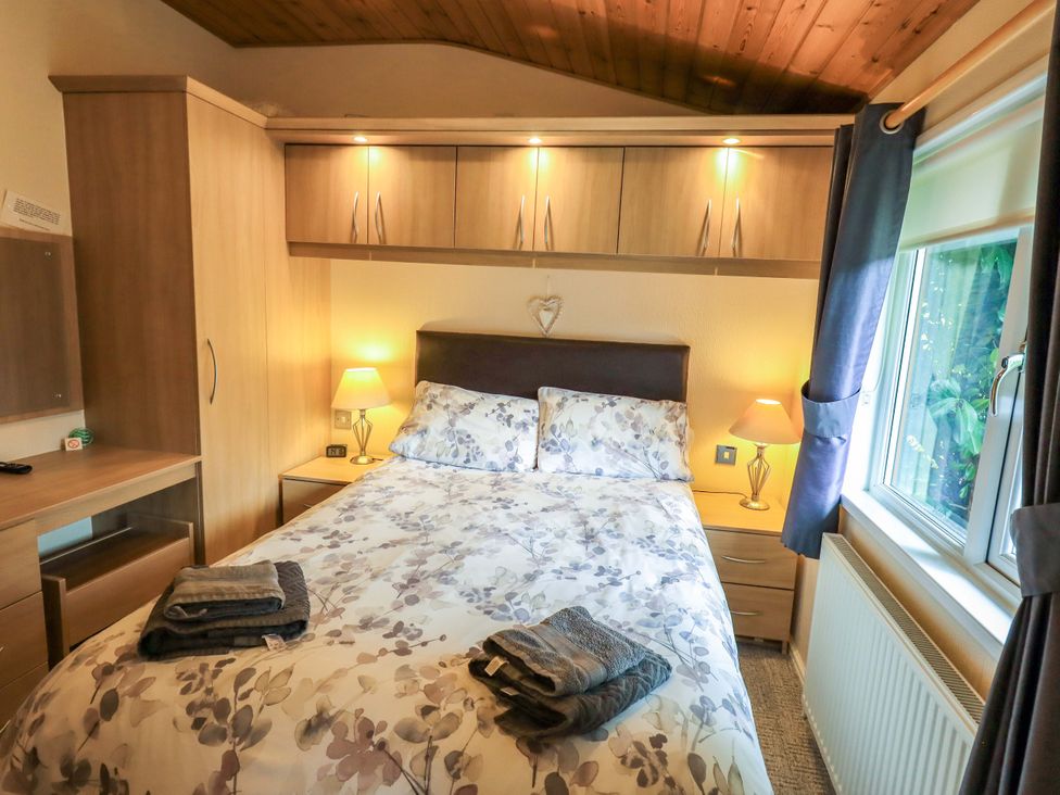 A bedroom with a bed and bedside table at Birthwaite Lodge, Fellside 6, Limefitt Park near Windermere