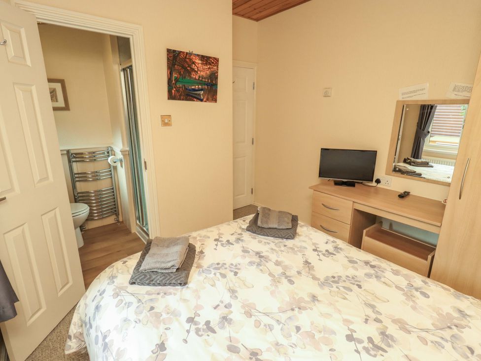 A bedroom with a bed and television at Birthwaite Lodge, Fellside 6, Limefitt Park near Windermere