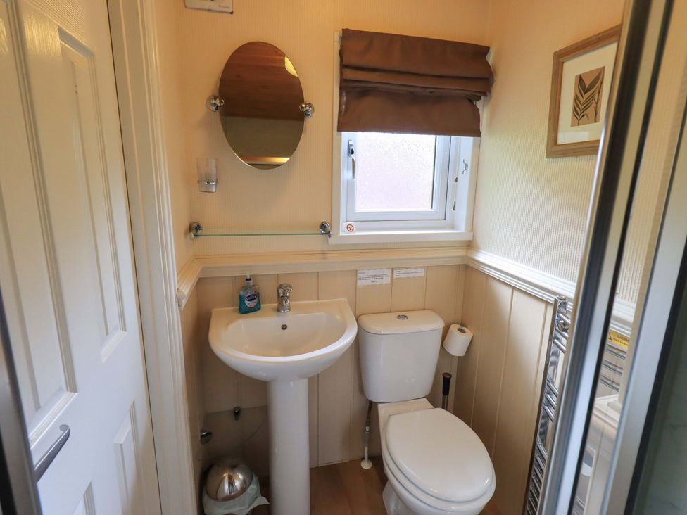 A bathroom with a sink, toilet, and window at Birthwaite Lodge, Fellside 6, Limefitt Park near Windermere