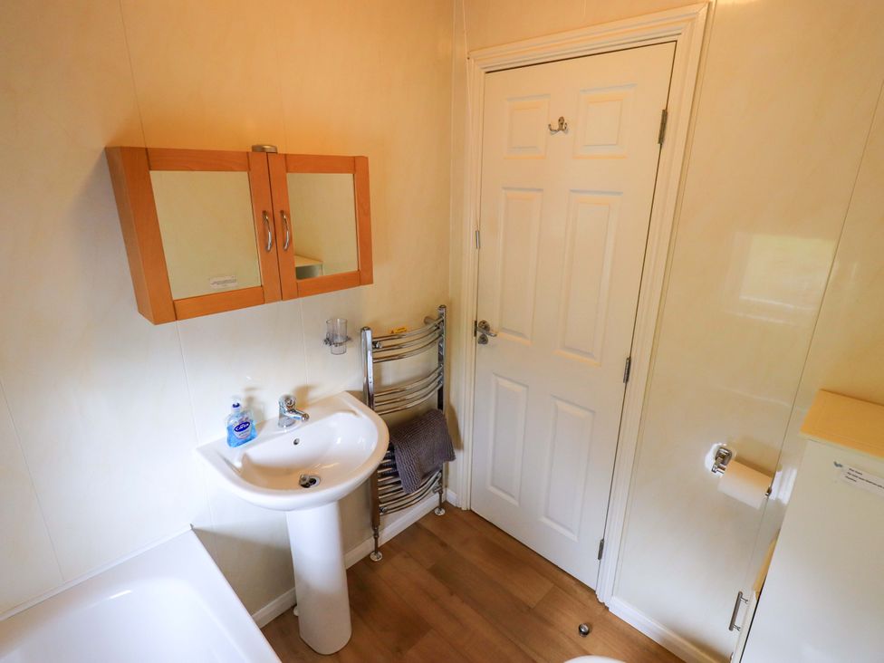 A bathroom with a sink and mirror at Birthwaite Lodge Fellside 6 Limefitt Park near Windermere