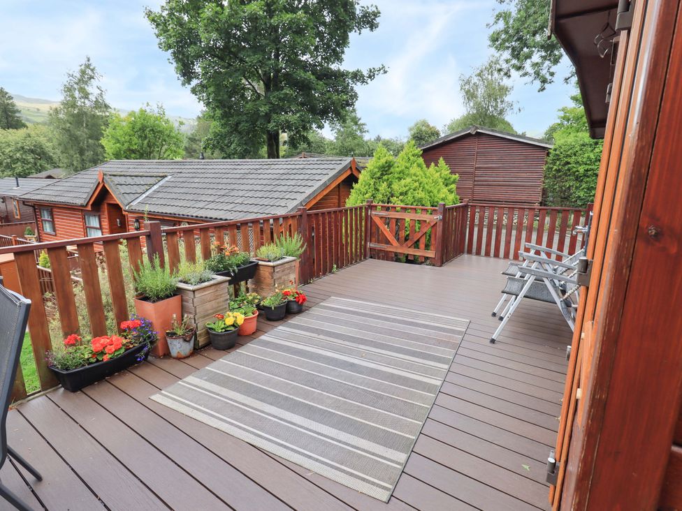 A deck with planters and chairs at Birthwaite Lodge, Fellside 6, Limefitt Park near Windermere