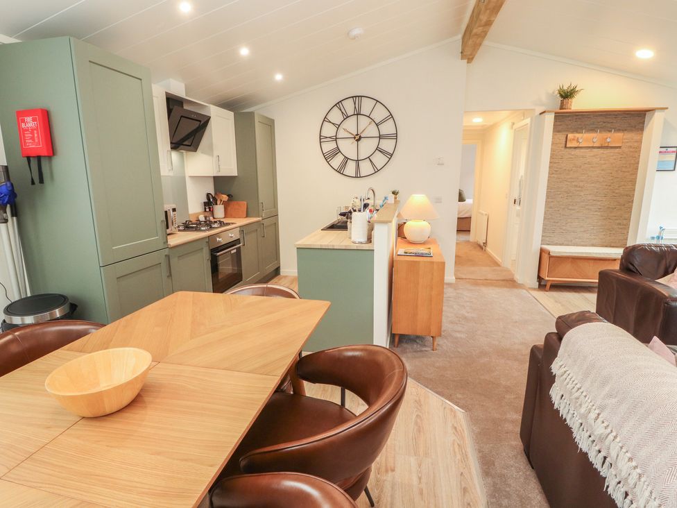 A kitchen and living area with dining table at Beech Grove Lodge, Glade 17, Fallbarrow Park near Bowness on Windermere