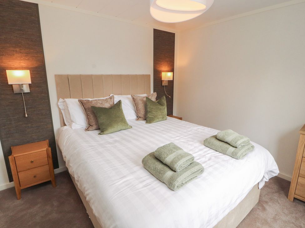 A bedroom with a bed and pillows at Beech Grove Lodge, Glade 17, Fallbarrow Park near Bowness on Windermere