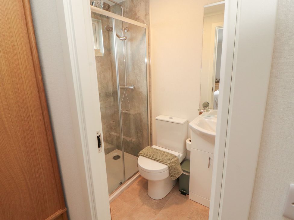 A bathroom with shower, toilet, and sink at Beech Grove Lodge in Glade 17, Fallbarrow Park near Bowness on Windermere