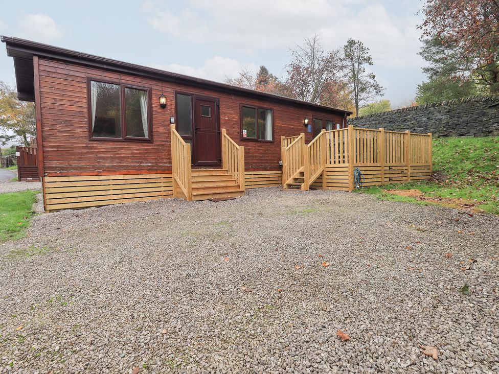 A wooden cabin with steps and a gravel driveway at Robin View Lodge, Beckside 3, Limefitt Park near Windermere