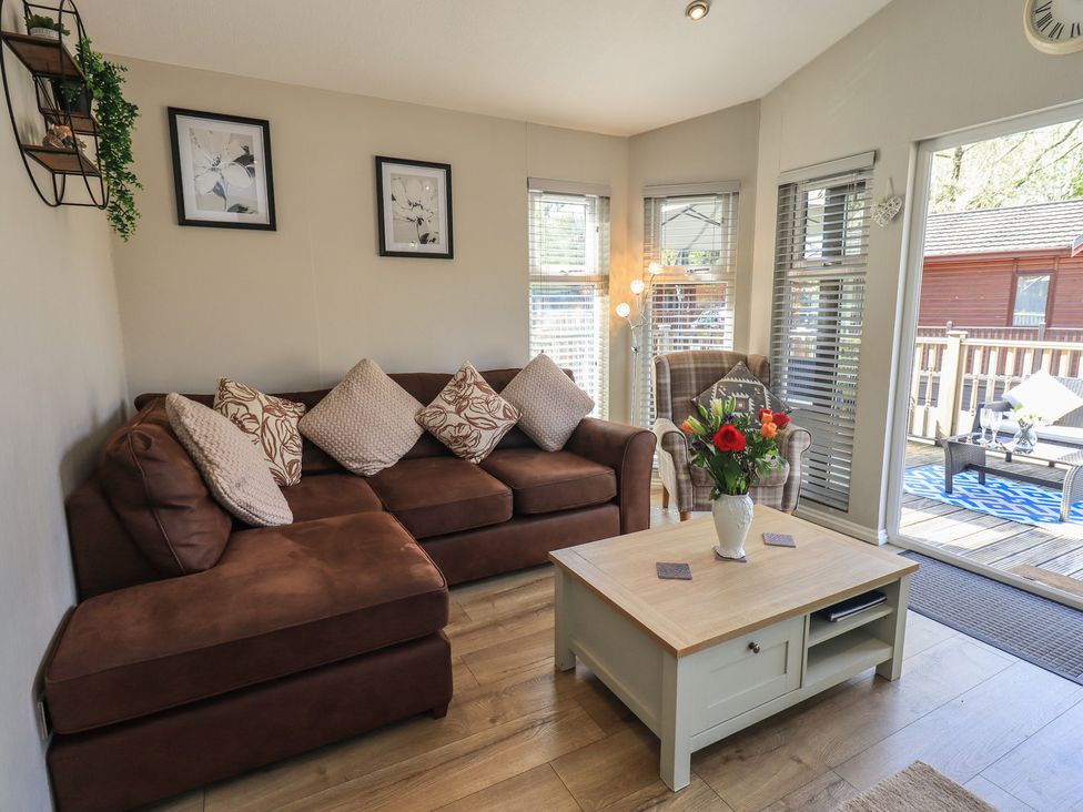 A living room with a sofa and coffee table at Badgers Hollow Lodge, Grasmere 30, White Cross Bay near Windermere