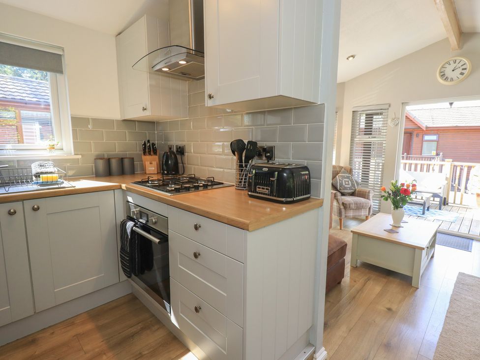 A kitchen with a stove and toaster at Badgers Hollow Lodge Grasmere 30, White Cross Bay near Windermere