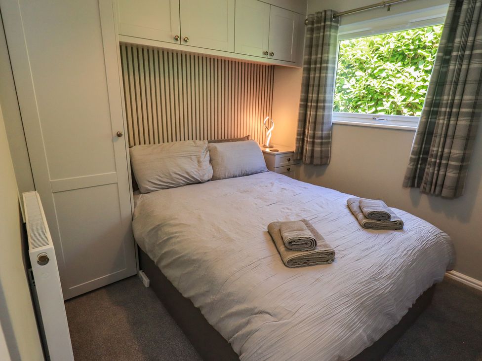 A bedroom with a bed and bedside table at Badgers Hollow Lodge, Grasmere 30, White Cross Bay near Windermere
