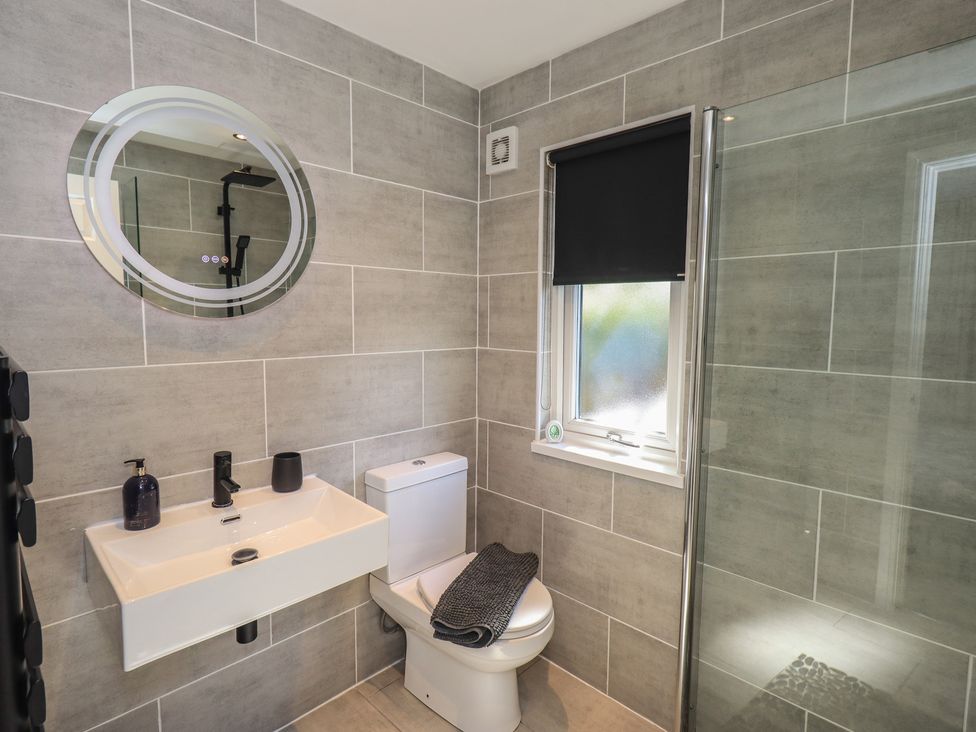 A bathroom with a sink, toilet, and shower at Badgers Hollow Lodge, Grasmere 30, White Cross Bay near Windermere