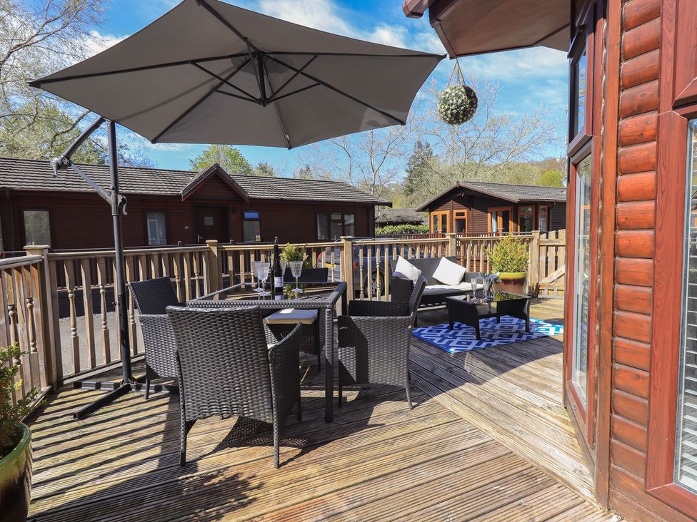 An outdoor seating area with table and chairs at Badgers Hollow Lodge Grasmere 30 White Cross Bay near Windermere