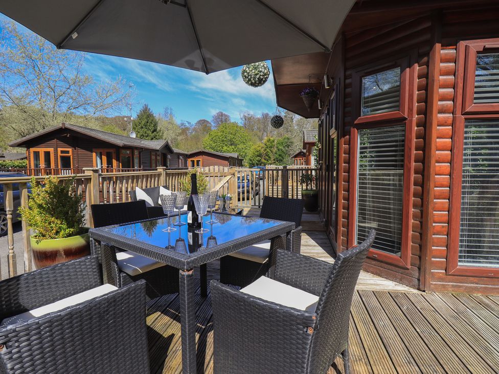 An outdoor seating area with a table and chairs at Badgers Hollow Lodge Grasmere 30, White Cross Bay near Windermere