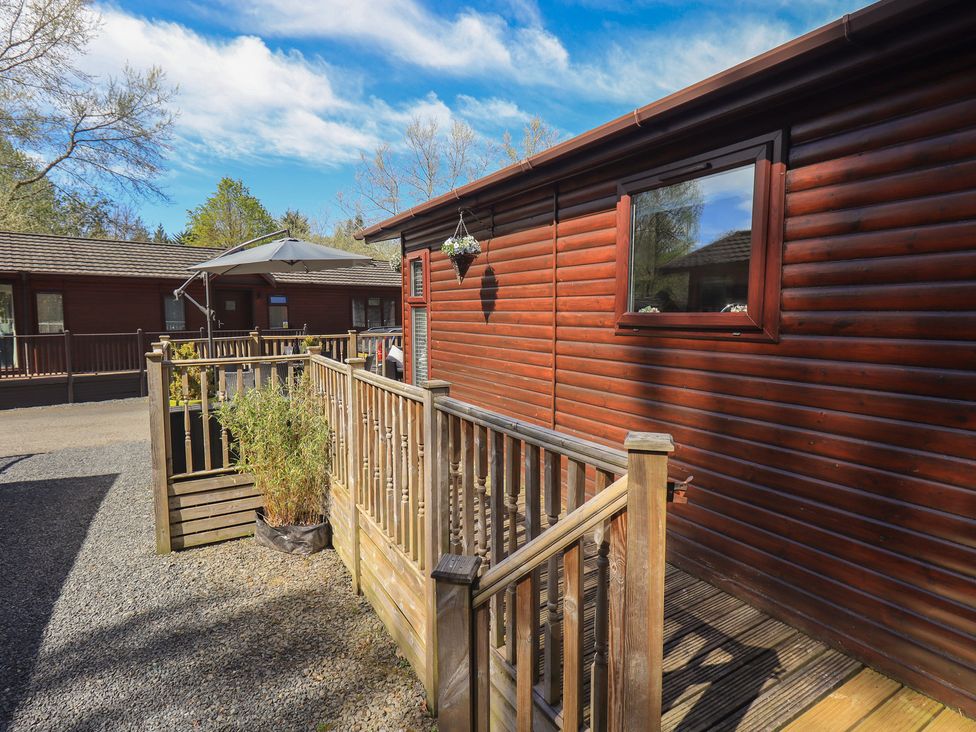 An outdoor area with a wooden lodge and decking at Badgers Hollow Lodge in Grasmere 30, White Cross Bay near Windermere