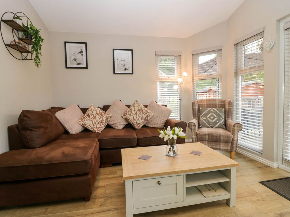 A living room with a sofa and coffee table at Badgers Hollow Lodge, Grasmere 30, White Cross Bay near Windermere