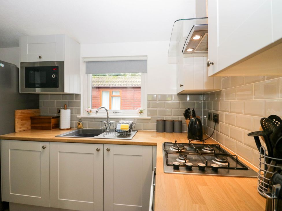 A kitchen with a sink and gas cooker at Badgers Hollow Lodge Grasmere 30, White Cross Bay near Windermere