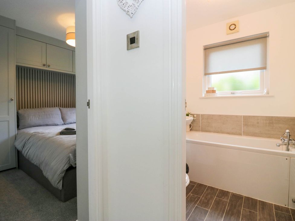 A bathroom with a bathtub and a toilet at Badgers Hollow Lodge, Grasmere 30, White Cross Bay near Windermere