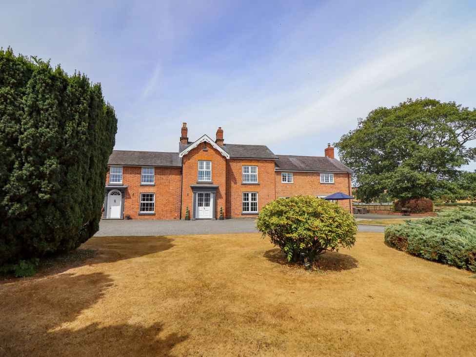 A house with a gravel driveway and bushes at Bodaioch Hall in Trefeglwys near Caersws
