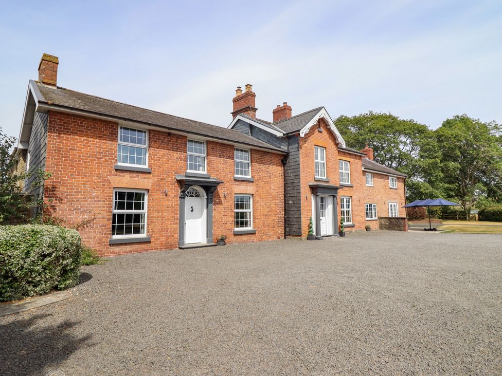 An outdoor area with a brick building and gravel driveway at Bodaioch Hall Trefeglwys near Caersws